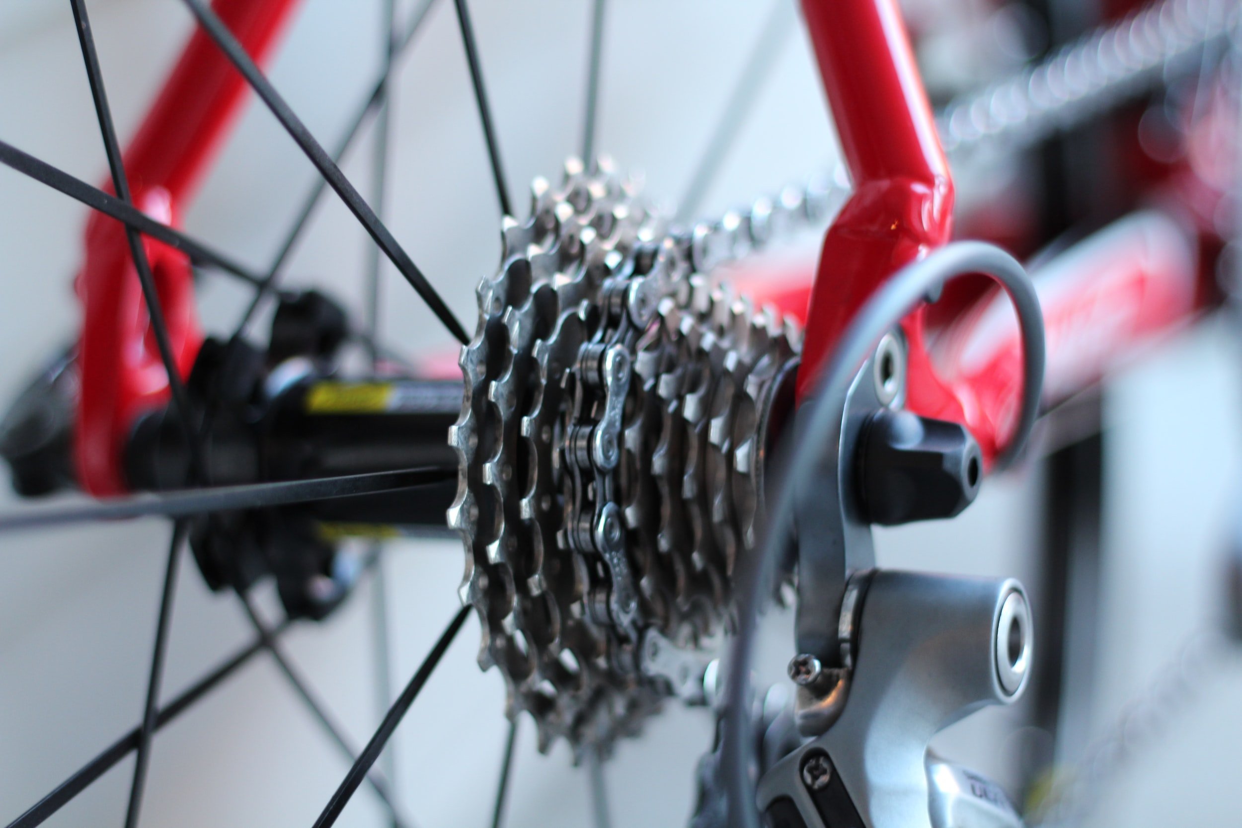 Close-up of a bicycle cassette and chain beside a red frame